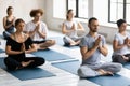 Young motivated multiracial people enjoying meditating with closed eyes.