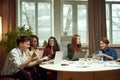 Young motivated people, students of university sitting at table and studying,. preparing for exams together. Royalty Free Stock Photo