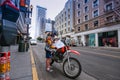 Young motorcyclist checking directions on map at city street