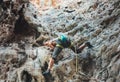 Young mountain climber climbing on Climbing Route using rope on Tonsay beach in Krabi, Thailand