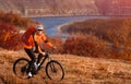 Young mountain cyclist riding bicycle under the river against beautiful landscape.