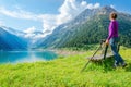 Young mountaineer by mountain lake and high peaks Royalty Free Stock Photo