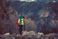 Young mountaineer standing with backpack on top of a mountain Royalty Free Stock Photo