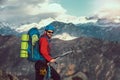 Young mountaineer standing with backpack on top of a mountain Royalty Free Stock Photo