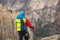 Young mountaineer standing with backpack on top of a mountain