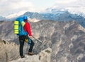 Young mountaineer standing with backpack on top of a mountain Royalty Free Stock Photo