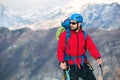 Young mountaineer standing with backpack on top of a mountain Royalty Free Stock Photo