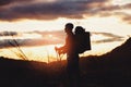 Young mountaineer standing with backpack on top of a mountain Royalty Free Stock Photo