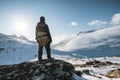 Young mountaineer standing on snowy hill with sunlight shine on winter at Lofoten Islands