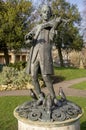 Young Mozart statue at a park with cloudy sky