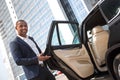 Young man manager standing with car door opened looking camera welcoming Royalty Free Stock Photo