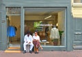 Young multi-ethnic couple sitting in front of a fashion store in the historic center of Amsterdam, Netherlands Royalty Free Stock Photo