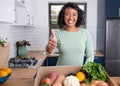 A young multi-ethnic customer gives thumbs up to fruit and veg box delivery Royalty Free Stock Photo