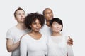 Young multi-ethnic friends in white t-shirts looking away over white background Royalty Free Stock Photo