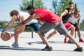 Young multicultural men playing basketball on court Royalty Free Stock Photo