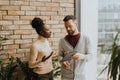 Young multiethnic business couple with digital tablet standing and discussing in the modern office Royalty Free Stock Photo