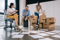 young multiethnic business people looking at papers on floor in new