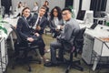 Young multiethnic businesspeople in formal wear sitting together and smiling at camera Royalty Free Stock Photo