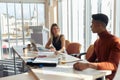 Young multiethnic colleagues talking in the bright office, looking each other Royalty Free Stock Photo