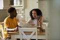 Young multiethnic couple reading a newspaper during breakfast at home Royalty Free Stock Photo