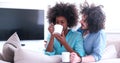 Multiethnic couple sitting on sofa at home drinking coffe Royalty Free Stock Photo