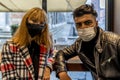 Young multiethnic couple wearing face masks indoors during coronavirus emergency