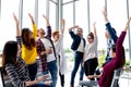 Young multiethnic diverse creative asian group huddle and high five hands together in office workshop with success or empower