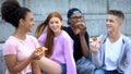 Young multiethnic friends laughing enjoying pizza, adolescence positivity, fun