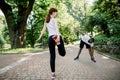 Young multiethnic jogging couple, Caucasian red haired girl and African guy, warming up and stretching before morning