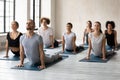 Young multiethnic people in activewear doing Bhujangasana Cobra pose. Royalty Free Stock Photo