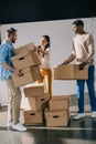 young multiethnic people holding cardboard boxes during relocation Royalty Free Stock Photo