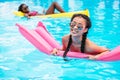 Young multiethnic women floating on inflatable mattresses in swimming pool