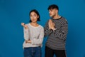 Young multiracial couple frowning and making pray gesture