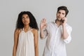 Young multiracial couple frowning while talking on mobile phone Royalty Free Stock Photo