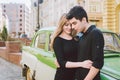 Young multiracial couple, male and female lovers heterosexual people students. Beautiful models posing standing near a retro car Royalty Free Stock Photo