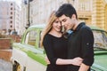 Young multiracial couple, male and female lovers heterosexual people students. Beautiful models posing standing near a retro car