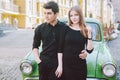 Young multiracial couple, male and female lovers heterosexual people students. Beautiful models posing standing near a retro car Royalty Free Stock Photo