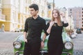 Young multiracial couple, male and female lovers heterosexual people students. Beautiful models posing standing near a retro car Royalty Free Stock Photo