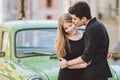 Young multiracial couple, male and female lovers heterosexual people students. Beautiful models posing standing near a retro car Royalty Free Stock Photo