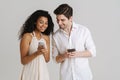 Young multiracial couple smiling while using mobile phones Royalty Free Stock Photo