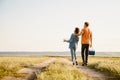 Young couple walking with cooler bag and map on county road Royalty Free Stock Photo