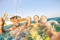 Young multiracial friends taking selfie and swimming on sailing boat tour