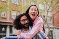 Young multiracial happy couple having fun embracing and hugging toguether. Caucasian bearded husband smiling and giving