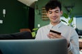 Young multiracial man in shirt using laptop and credit card in living room at home Royalty Free Stock Photo