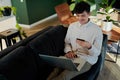 Young multiracial man smiling while using laptop and credit card on sofa at home Royalty Free Stock Photo