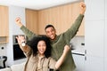 Young multiracial married couple smiling cheerfully and showing keys from a new apartment, hugging and looking at camera Royalty Free Stock Photo