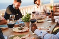 Young multiracial people eating and drinking red wine while wearing protective masks - Social distance concept - Focus on black Royalty Free Stock Photo