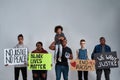 Young multiracial people and kid holding anti racist posters