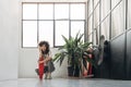 Young multiracial woman crouching down with skateboard looking at camera. Copy space. Royalty Free Stock Photo