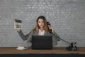 Young multitasking business woman sitting at desk Royalty Free Stock Photo